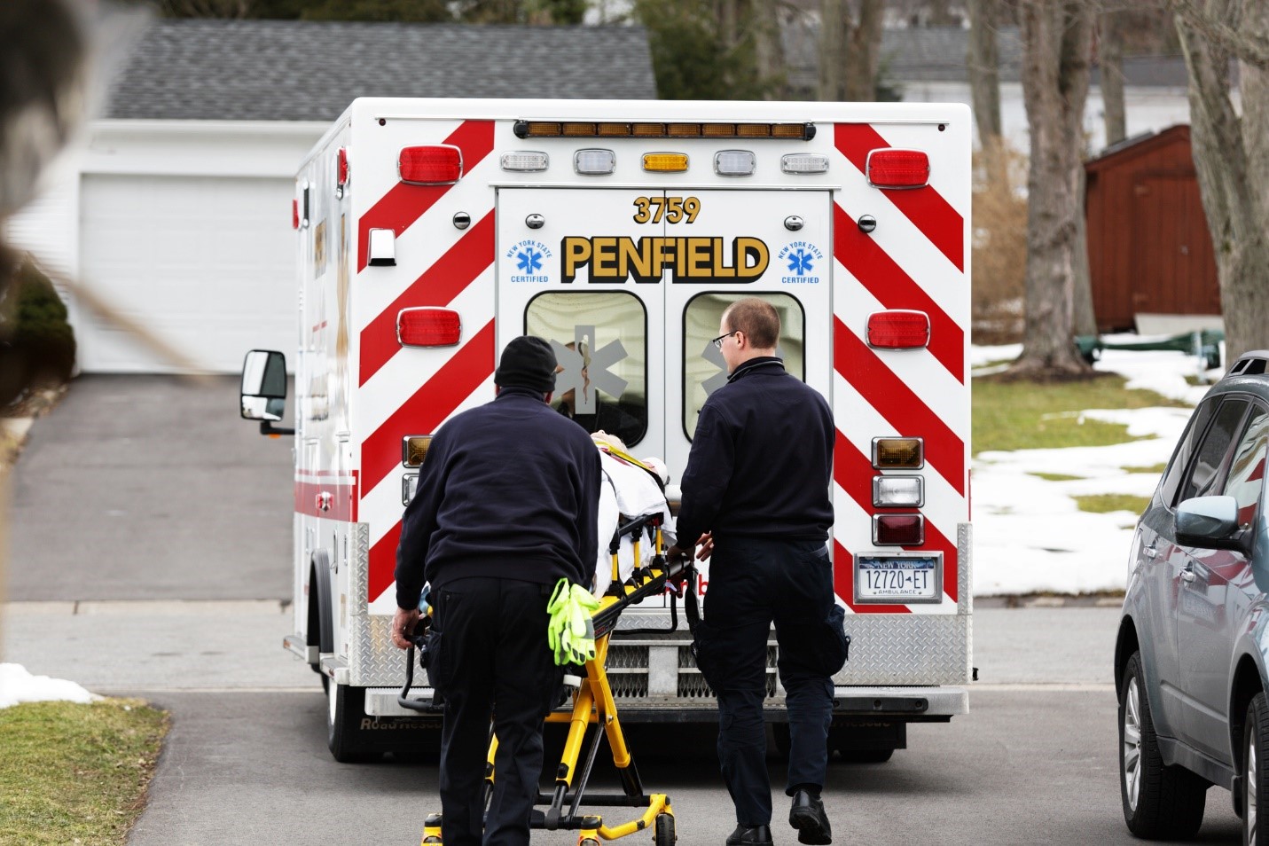 Paramedics carrying a patient in an ambulance

Description automatically generated